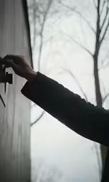 the person is holding the latch on a door