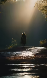 a person walks along a path on the edge of a stream as the sun rises
