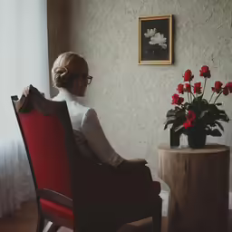 a woman sitting in a red chair with her back to the camera