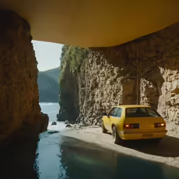 yellow vehicle parked in large body of water under cliff
