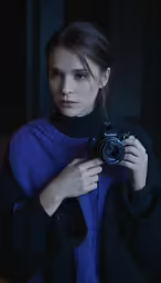 the woman in black sweater is holding her camera