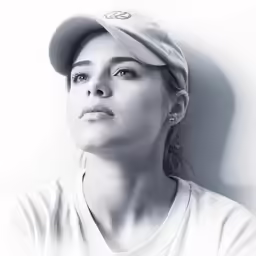 a black and white photo of a woman in a baseball cap