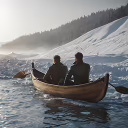 two people sitting in a wooden boat on a snowy mountain