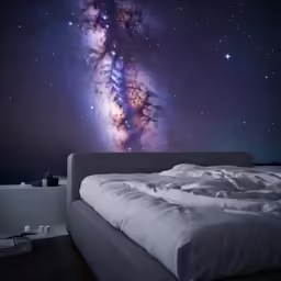 the bed is made and has an image on the wall