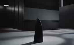a large black vase in an empty space