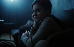 a woman is sitting on a couch and looking away