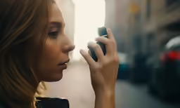 a woman looks at her phone on the street