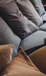 an upholstered couch with cushions on the back of it