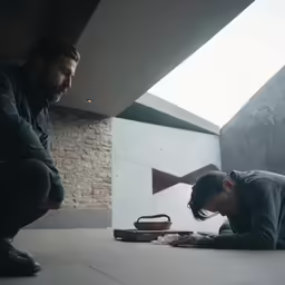 a man standing in front of a door while looking at his phone