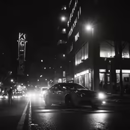some cars on the street at night with building lights