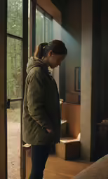 woman standing outside of a large window with a lit candle on it