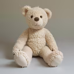there is a teddy bear with fluffy fur sitting on the ground