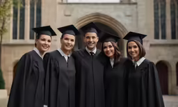 a group of graduates posing for a photo in front of the quad