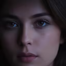 a closeup photo of a woman with dark hair and blue eyes