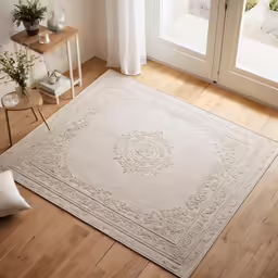 the rug in front of a door has a white floor and wooden floors