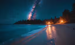 a snowy road next to a lake at night