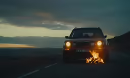 a car with its headlights on is shown