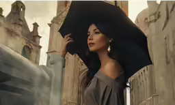 a beautiful woman in black standing next to a large building