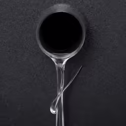 two spoons sitting next to each other on a black surface