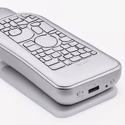 a remote on a white table top next to other remotes