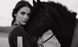 a young woman posing for a picture with her horse