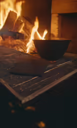 a bowl sitting on a table with flames behind it