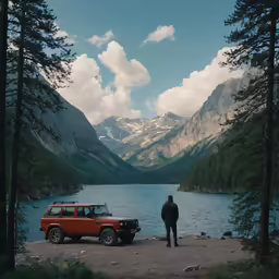 the jeep is parked at a lake in the mountains