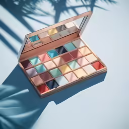 a makeup palette with its lid open, sitting on a blue table
