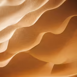 a person walks in the sand, casting patterns on the surface
