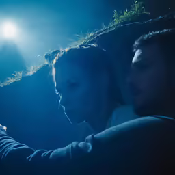 two people in the dark with their cell phones