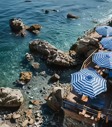 a wooden dock with umbrellas and chairs on top of it