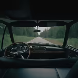 dashboard view of car on winding roadway in rural area