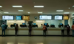 a long row of people waiting at a check - in counter