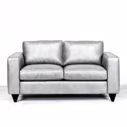 a leather couch sitting against a white wall