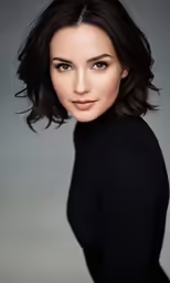 the woman is wearing a black shirt and looking into the camera