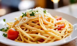 a white plate topped with pasta and garnish
