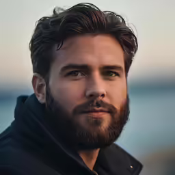 a bearded man posing for a picture in the middle of a day