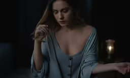 a woman with a very big breast standing in the dark