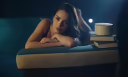 the beautiful woman is posing with her arm crossed near her head
