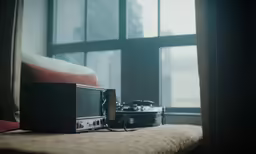 a pair of speakers sit on a chair by a window