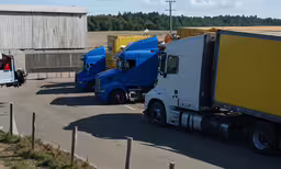 a fleet of semi trucks drives down a road,several semi trucks are parked next to each other