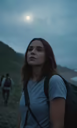 a woman with a backpack walking towards the sky