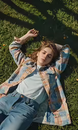 girl lying on the grass with hands in her hair