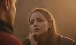 a woman is looking into the distance with her hand in her chin