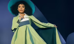 a woman in a green dress and large hat