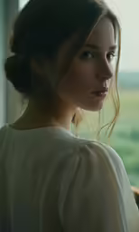 a beautiful woman looking out of a window