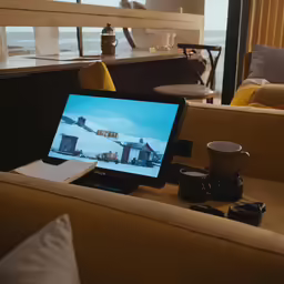 a laptop on the table with a cup of coffee in front of it