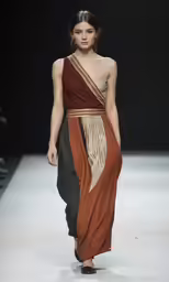 a model walks down the runway in a dress