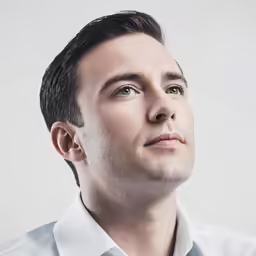 a man with a hair style is posing for a picture