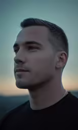 a man is standing in the sun with his head tilted